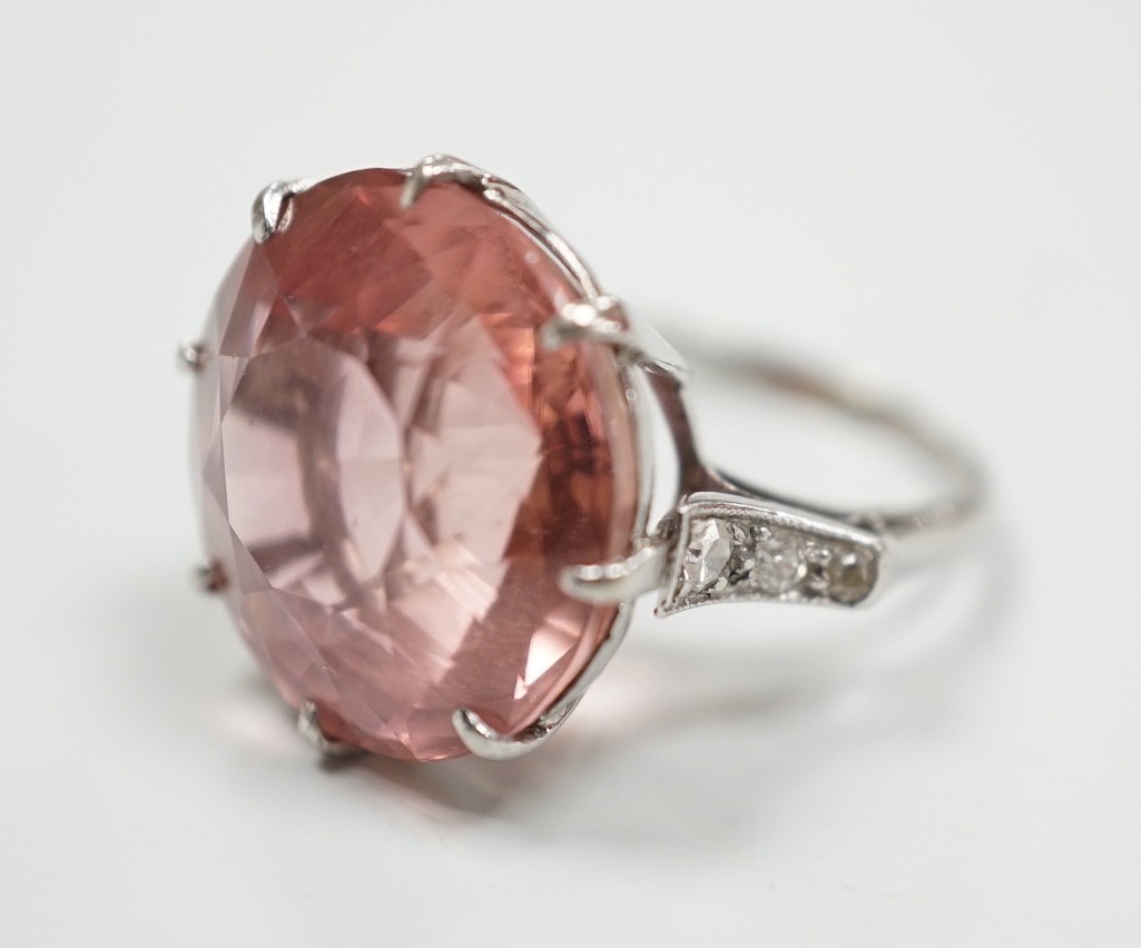 A white metal and circular cut pink tourmaline set dress ring, with three stone graduated diamond set shoulders, size I/J, gross weight 6.6 grams